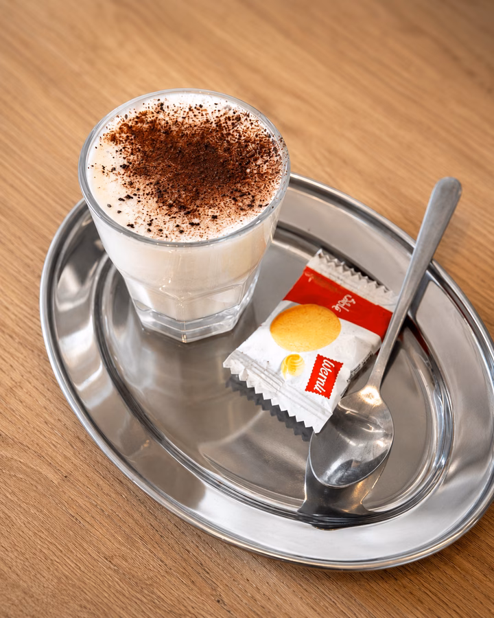 Babyccino mit Kakaopulver und Guetzli