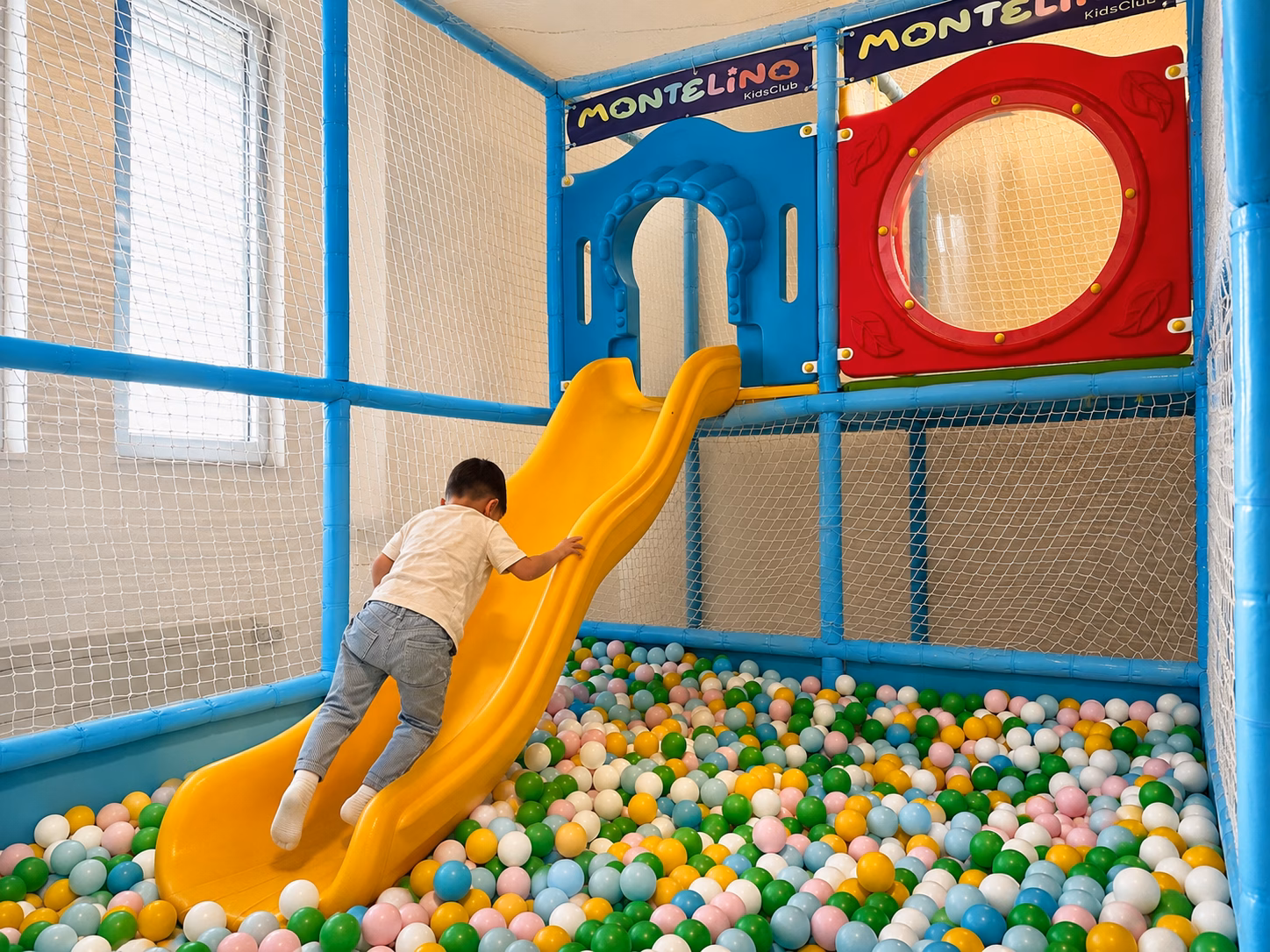 Kleinkind beim Klettern im Spielbereich